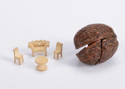 Lot 578 - An 19th century walnut shell with a miniature bone dolls’ house set of furniture