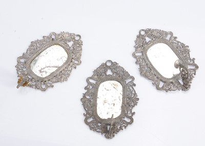 Lot 616 - Three matching late 19th century German soft metal mirrors with candle sconce