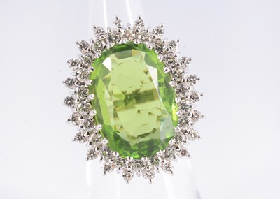 Lot 118 - An oval 15.3ct peridot & diamond cluster ring