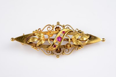 Lot 184 - An Edwardian gold ruby & diamond oval scroll & floral bar brooch