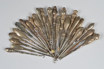 Lot 211 - Twenty five silver and white metal handled steel button hooks