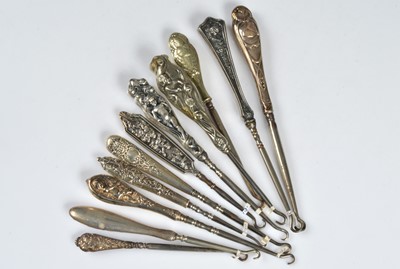 Lot 223 - Eleven cherub and angel handled button hooks
