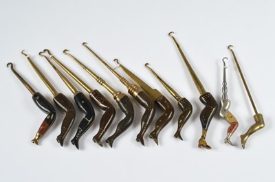 Lot 253 - A collection of ten art deco brass and ebonised novelty button hooks
