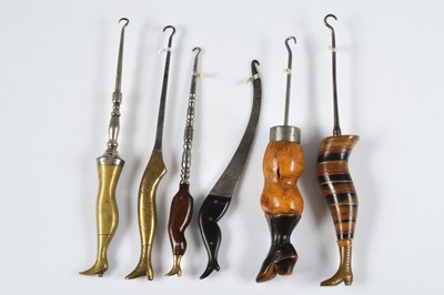 Lot 256 - A collection of six treen, brass, ebonised and banded novelty button hooks