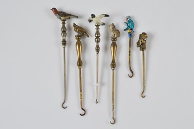 Lot 270 - A collection of six cold painted and enamelled novelty button hooks