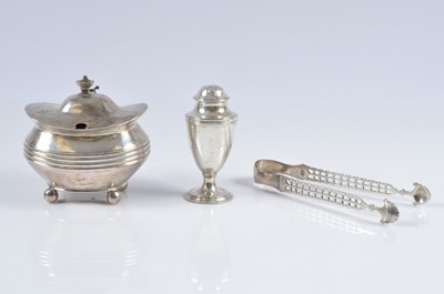 Lot 328 - A George III silver mustard pot and a pair of sugar nips and pepper pot