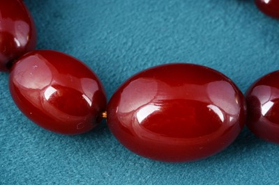 Lot 22 - A long string of 'cherry amber' beads