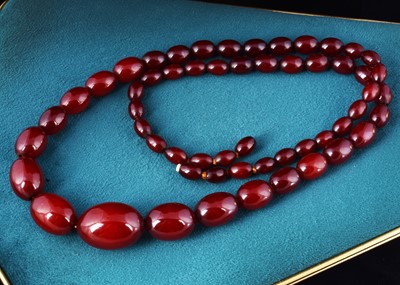Lot 22 - A long string of 'cherry amber' beads