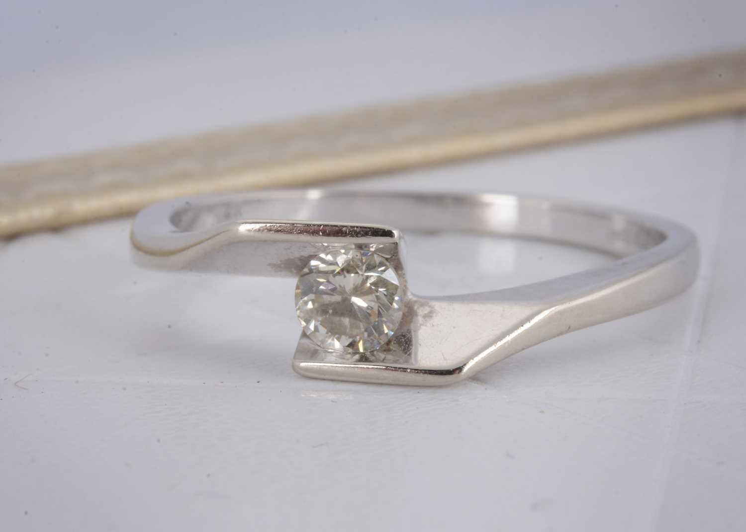 Lot 15 - An 18ct gold diamond crossover solitaire dress ring