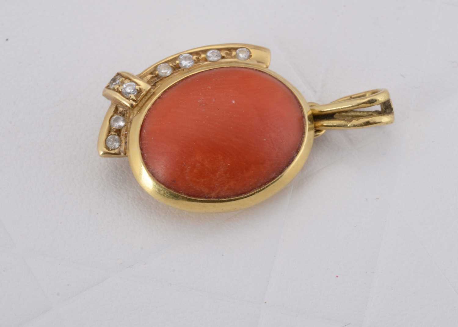 Lot 72 - A continental coral and diamond set oval pendant