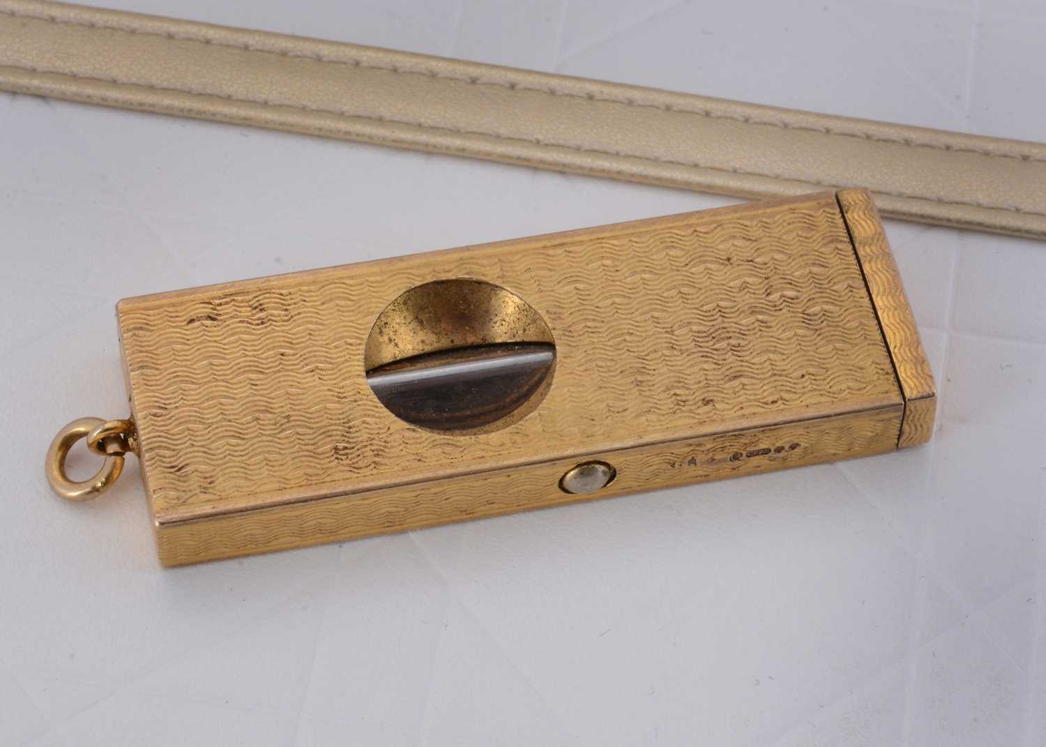 Lot 74 - A 9ct gold engine turned and sprung movement cigar cutter