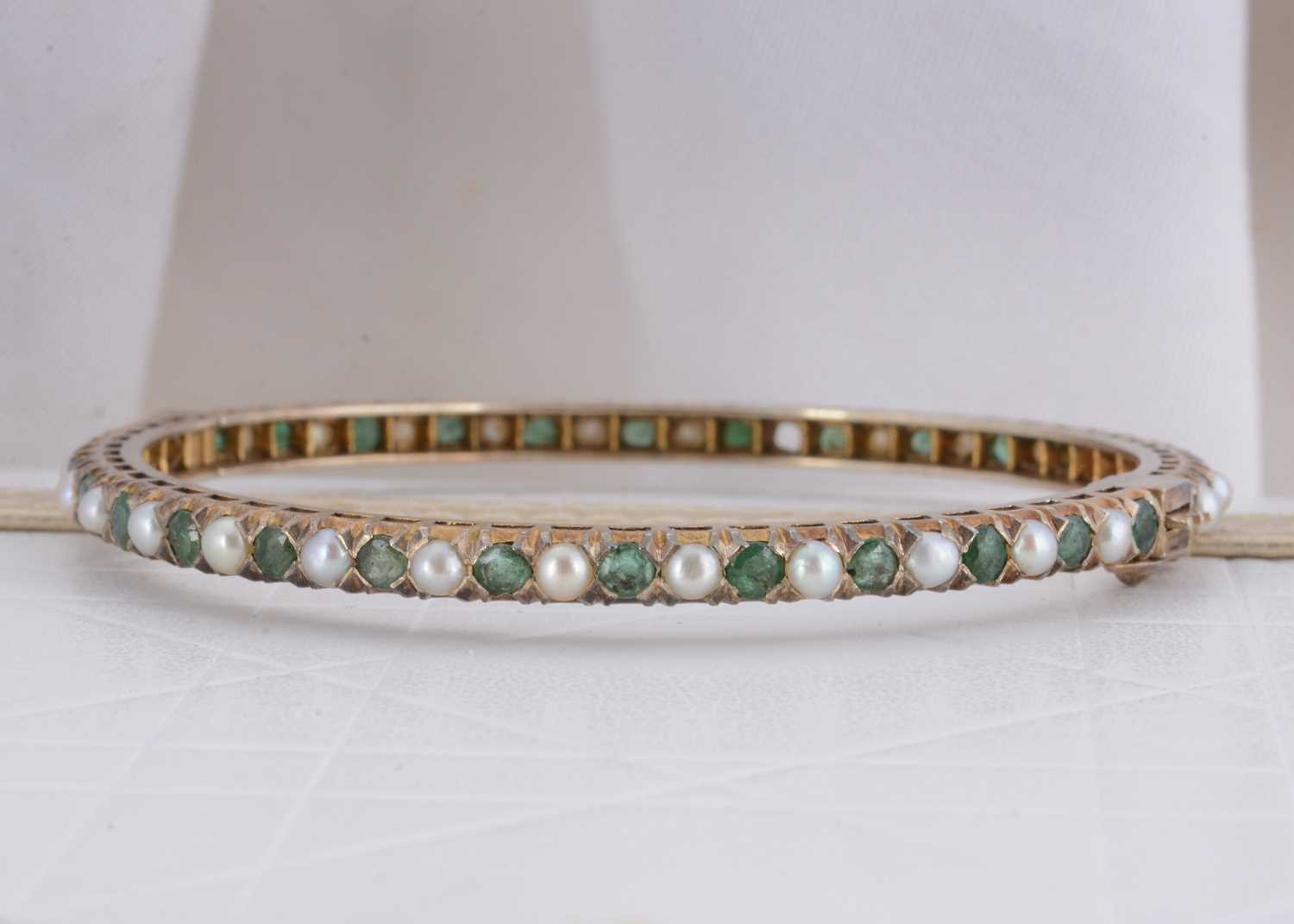 Lot 78 - An Indian emerald and pearl silver gilt hinged bangle