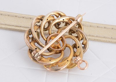 Lot 116 - An Edwardian openwork circular scroll target brooch or pendant