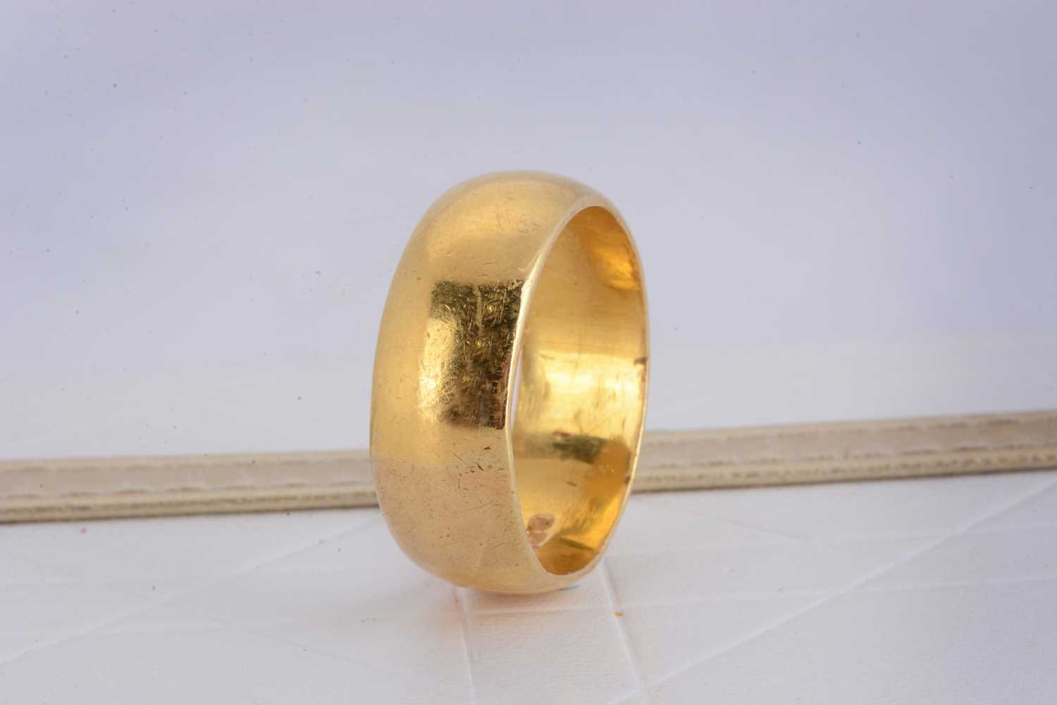 Lot 166 - An Elizabeth II 22ct gold barrel shaped wedding band
