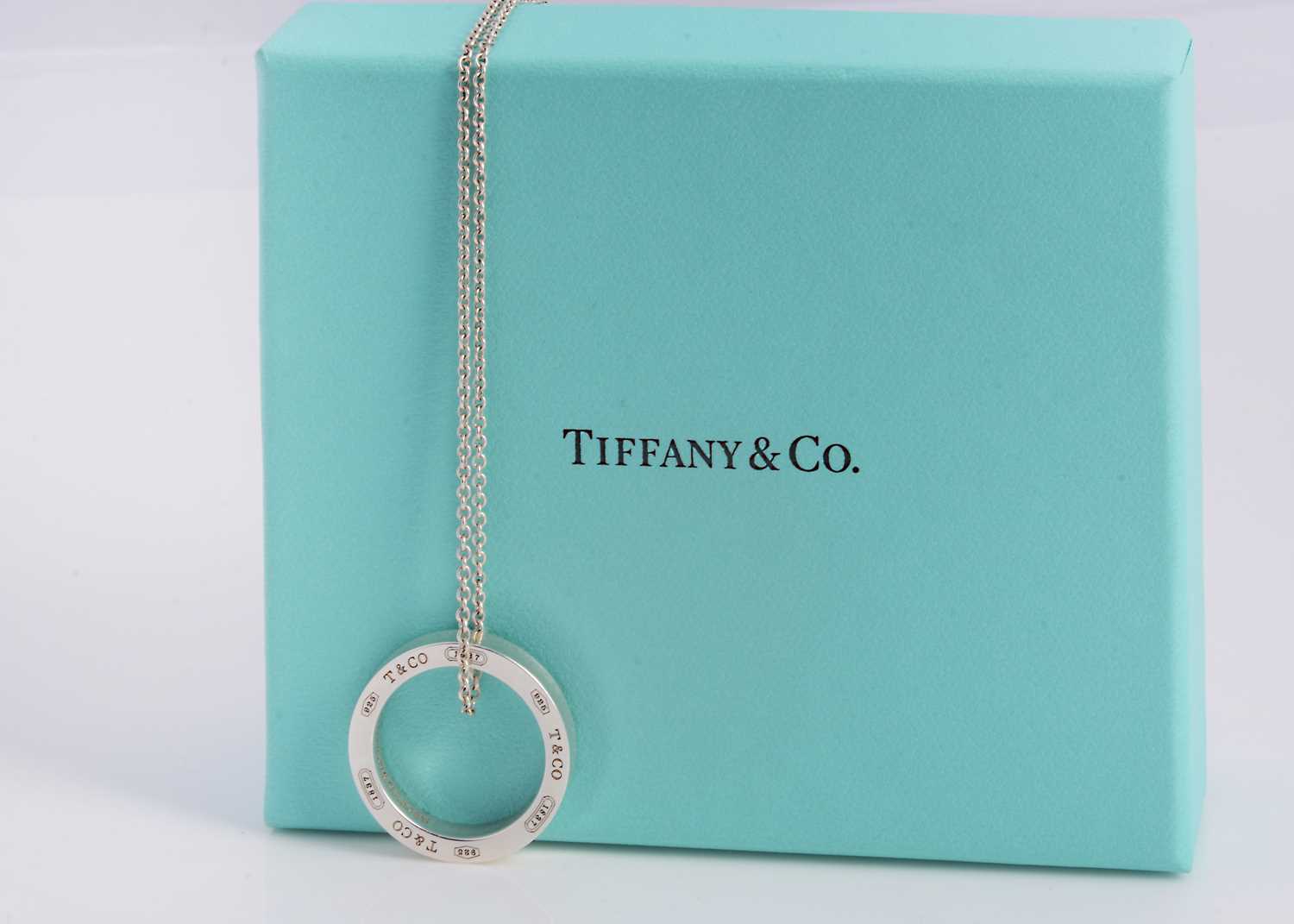 Lot 64 - A silver Tiffany & Co circle band pendant necklace, in turquoise box marked Tiffany & Co