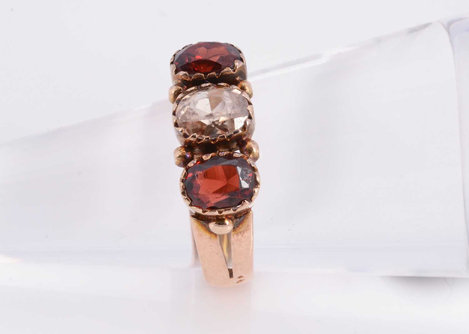 Lot 84 - A 9ct rose gold three stone garnet dress ring