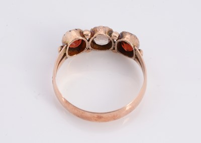 Lot 84 - A 9ct rose gold three stone garnet dress ring