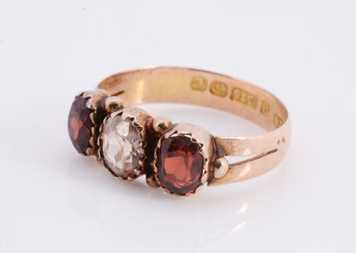 Lot 84 - A 9ct rose gold three stone garnet dress ring